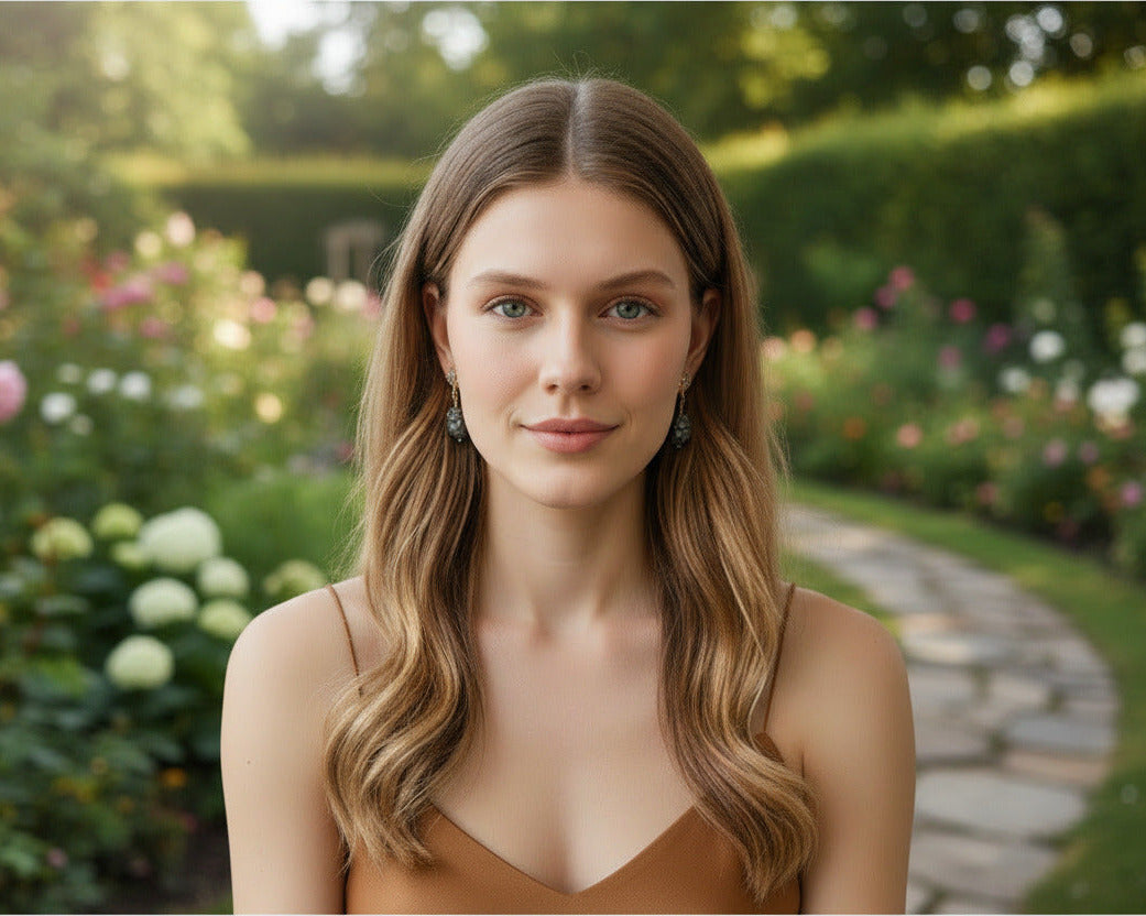 Woman standing in a garden with flowers and a path in the background