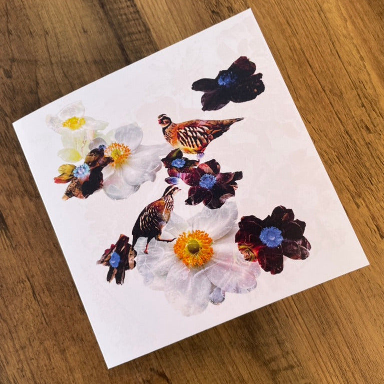 flowers and partridges on a white card with a wooden surface background