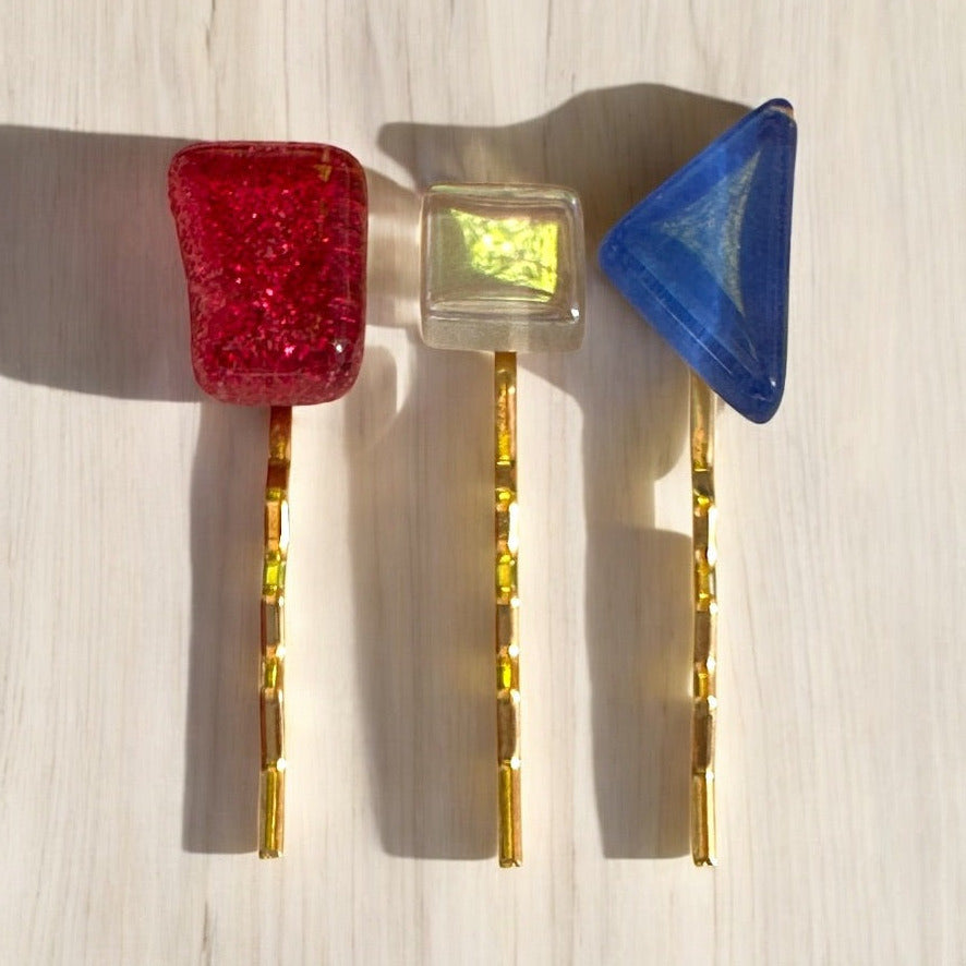 Set of colorful hair clips on a light wooden surface