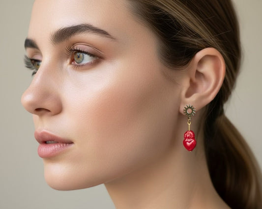 Close-up of a woman wearing a red heart-shaped earring with a neutral background