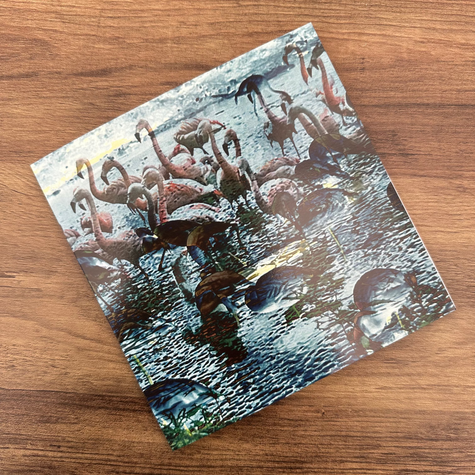 Card design of flamingos bathing on a wooden surface