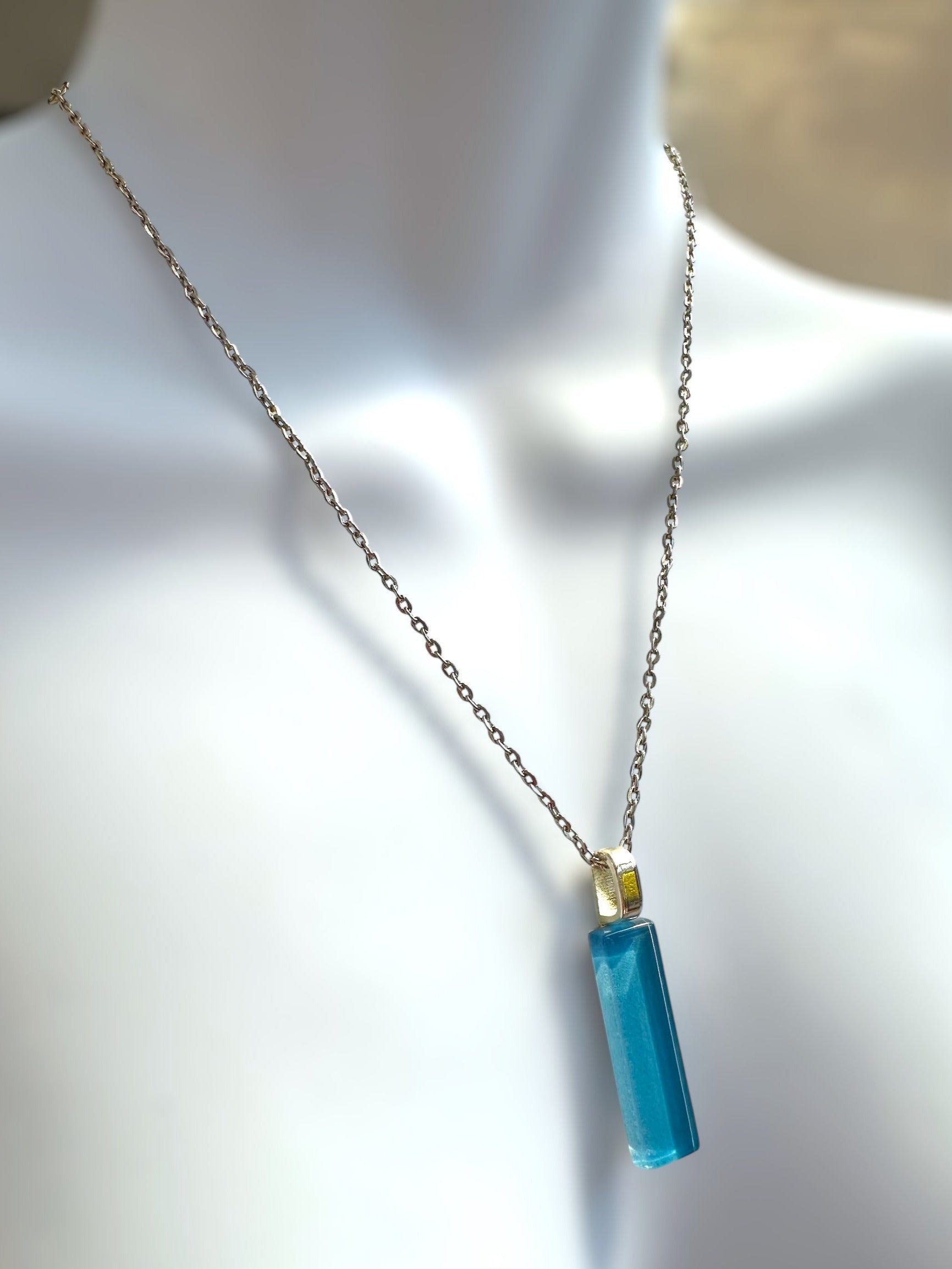 Necklace with a blue glass bar pendant on a mannequin